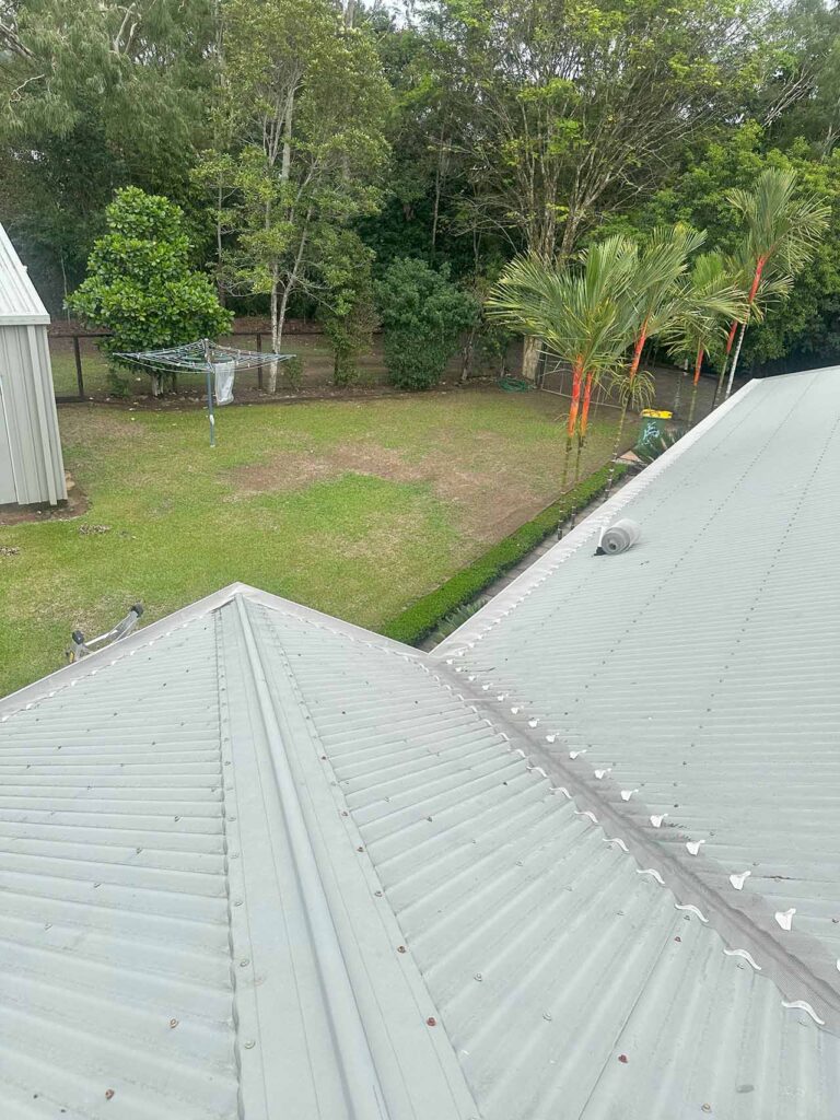 Aluminium gutter guard installed along roof valley of Smithfield home near bushland